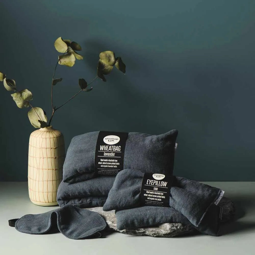 Set of dark gray eye pillows with labels on a dark green background