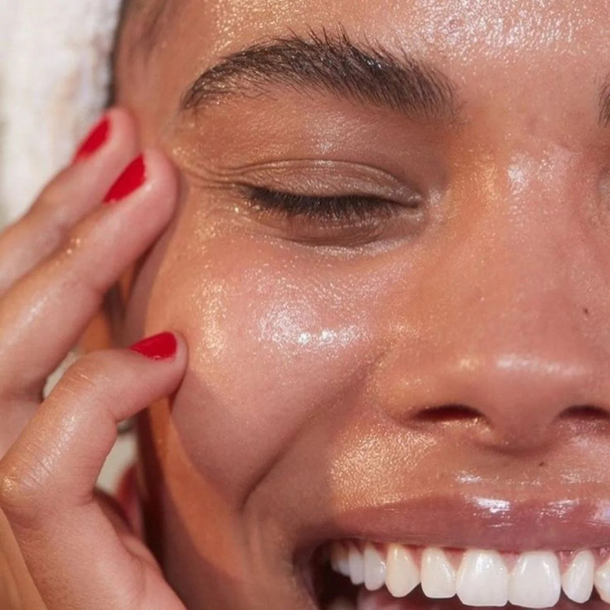 Close-up of a person applying a Jojoba product to their face.